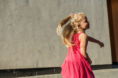 Young woman standing against wall