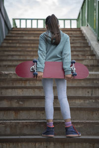 Rear view of woman standing on staircase