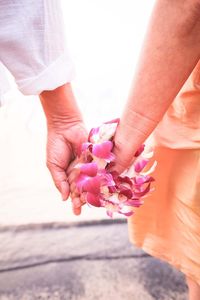 Cropped image of woman holding white flower