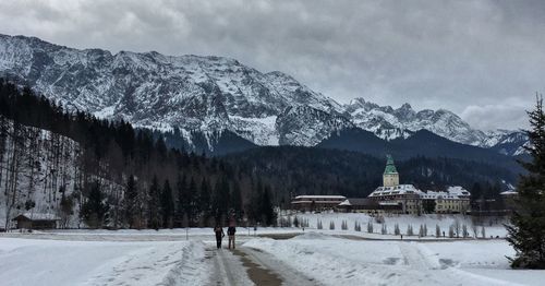 People walking on street against bavarian alps