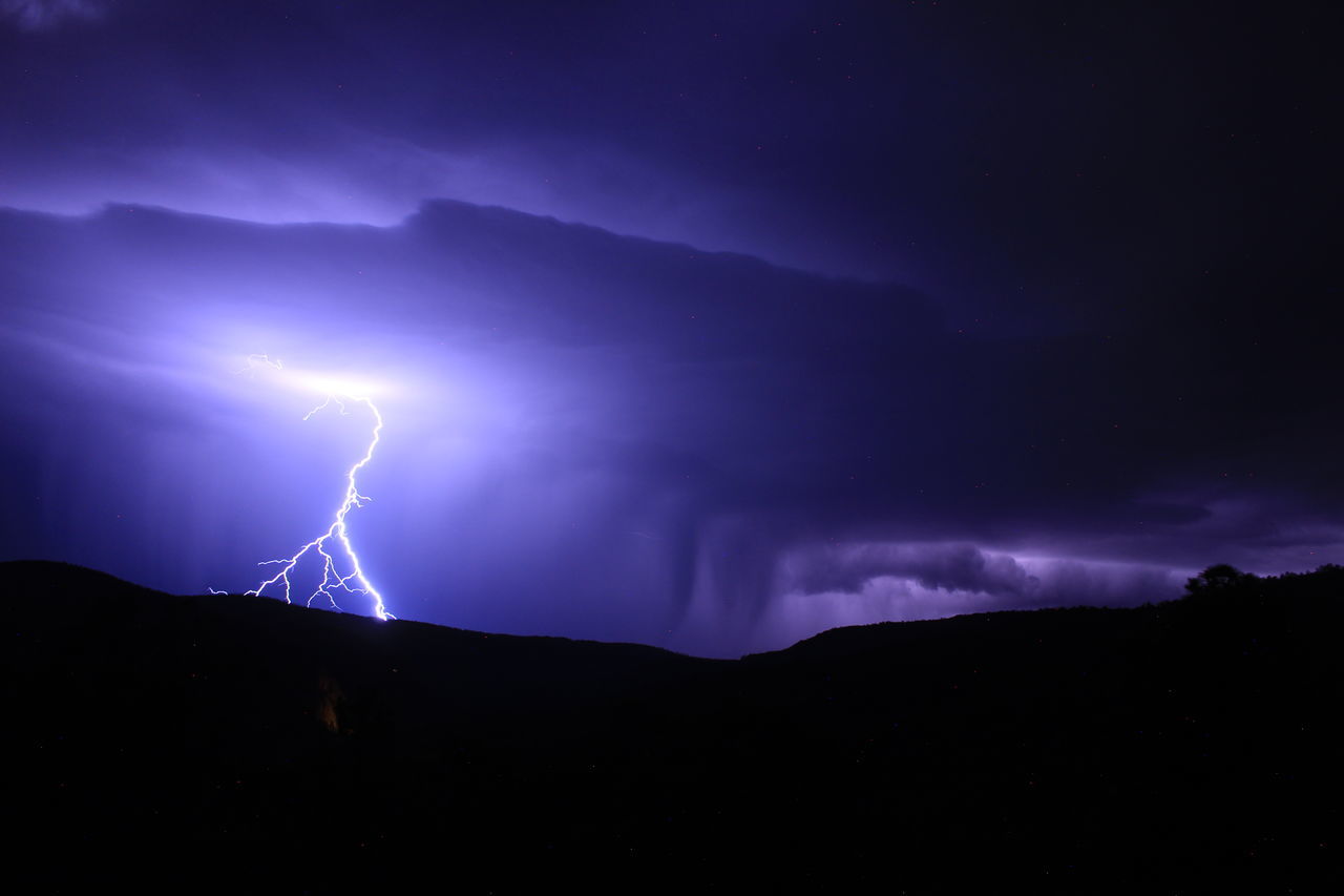 lightning, power in nature, storm, thunderstorm, cloud, beauty in nature, thunder, night, warning sign, sky, environment, dramatic sky, storm cloud, forked lightning, sign, communication, nature, electricity, mountain, scenics - nature, no people, purple, darkness, outdoors, extreme weather, awe, dark, landscape, bolt, atmospheric mood, light - natural phenomenon, illuminated, silhouette