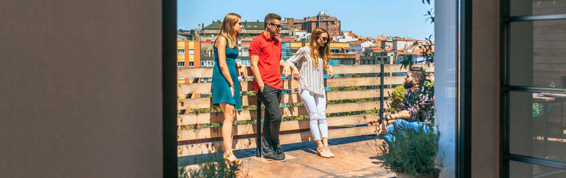 View of friends group talking in rooftop through lounge window