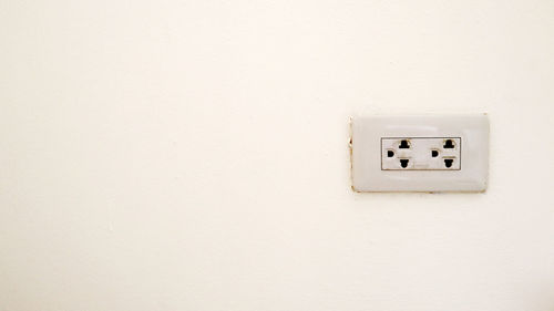 Close-up of switch board on white wall