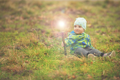 Full length of cute baby girl sitting on field