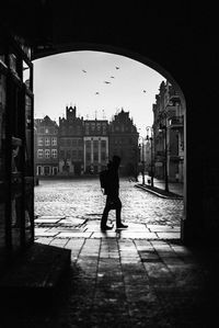 Silhouette man walking in city