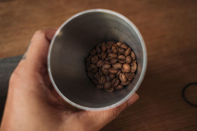 High angle view of hand holding coffee cup