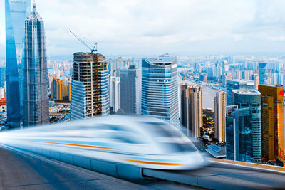 Blurred motion of modern buildings against sky in city