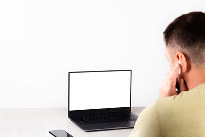 Man using mobile phone against white background