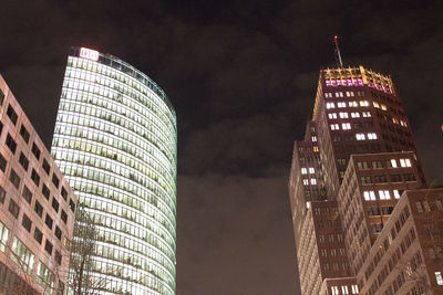 Low angle view of illuminated buildings against sky at night