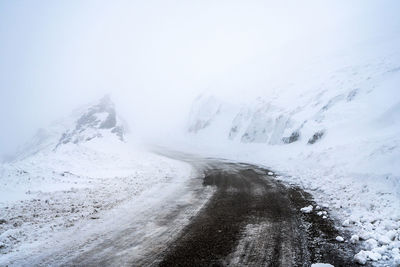 Scenic view of snowcapped mountains and road against sky