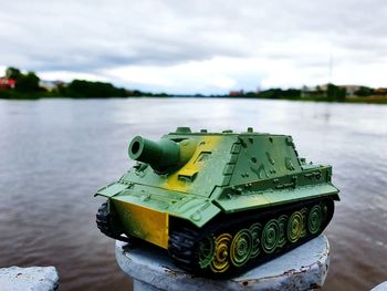 Close-up of toy by river against sky