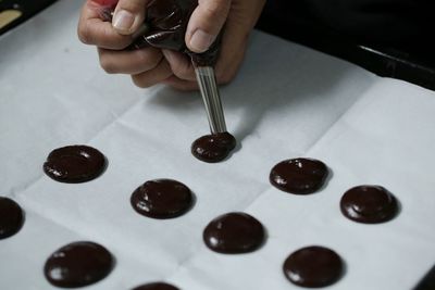 Cropped hands of person preparing food on wax paper