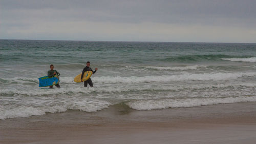 People on beach against sky