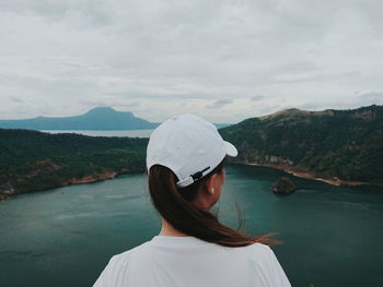 Rear view of woman standing on mountain against sky