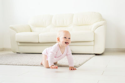 Cute baby girl on sofa at home