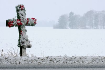 Snow covered cross on field