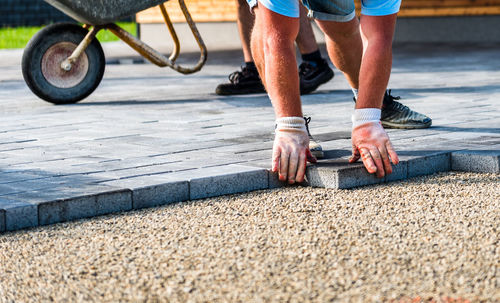 Construction worker arranging paving stones on street