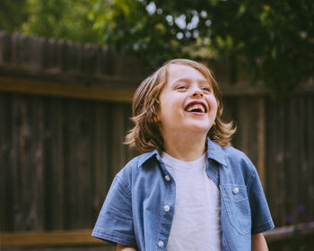 Cute boy laughing in back yard