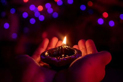 Hand holding lightened diya