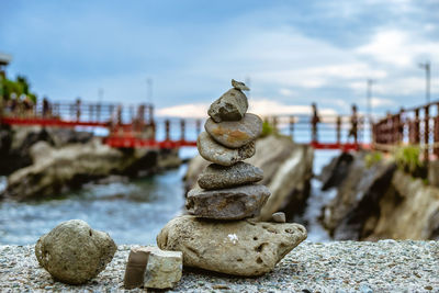 Stack of pebbles on rocks against sky