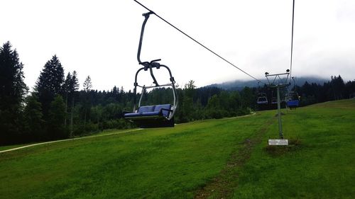 Overhead cable car on field against sky