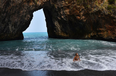 Teenage girl sitting on shore at beach