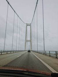 View of suspension bridge through car windshield