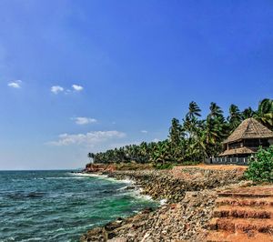 Scenic view of sea by building against blue sky