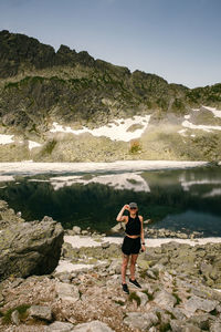 Full length of man standing on rock at shore