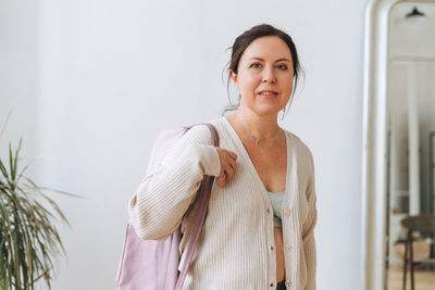 Portrait of a smiling young woman standing at home