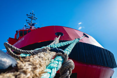 Low angle view of fishing boat moored against sky