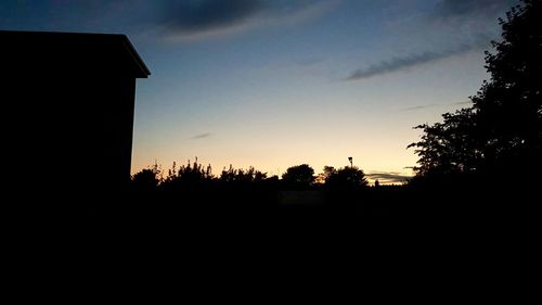 Low angle view of silhouette trees against sky