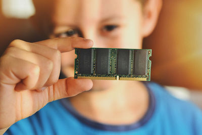 Close-up portrait of boy holding camera