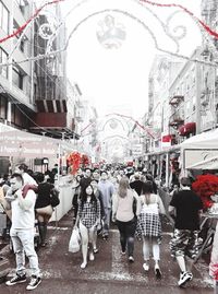 Rear view of people walking on street against buildings