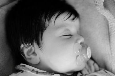 Close-up of cute baby sleeping on bed at home