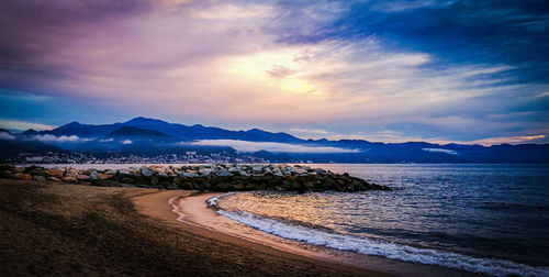 Scenic view of beach against sky during sunset