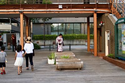 Full length of two people walking on sidewalk