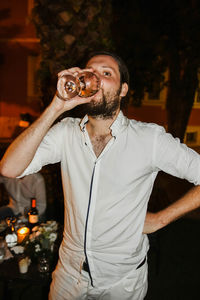 Midsection of man holding camera at night