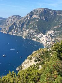 Scenic view of sea and mountains against clear blue sky