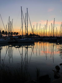 Sailboats in lake against sky during sunset