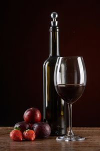 Close-up of wine glasses on table against black background