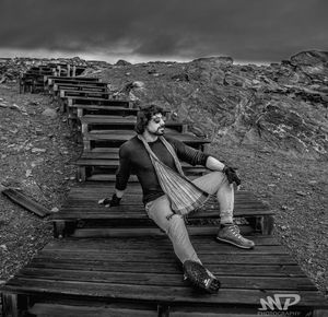 Man sitting on staircase against sky