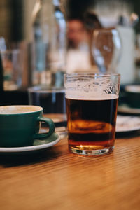 Close-up of coffee and beer on table