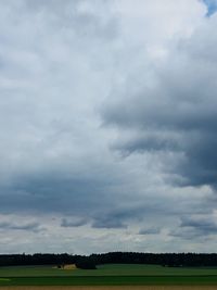 Scenic view of field against cloudy sky