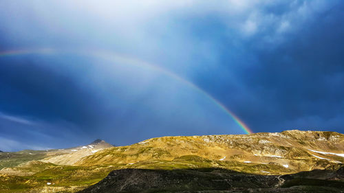 Low angle view of rainbow over mountain against sky