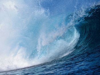 Waves splashing on sea against sky