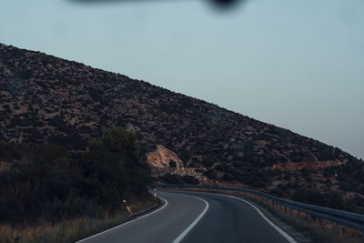 Empty road by mountain against sky