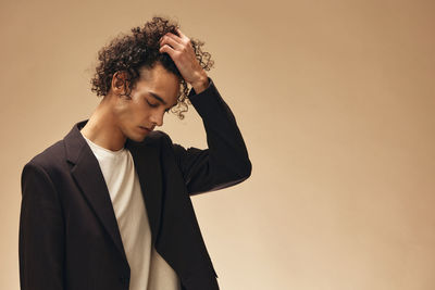 Side view of young man standing against clear sky