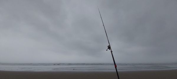 Wind turbines on beach against sky