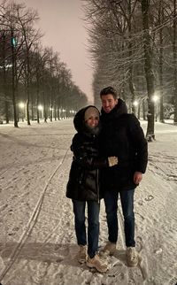 Portrait of friends standing on snow covered tree